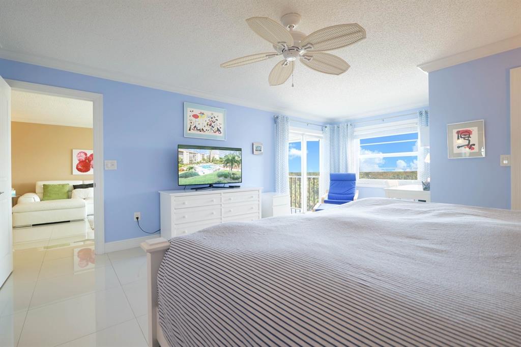 3930 Inverrary Boulevard, Unit 603D Lauderhill, FL 33319 - Photo 31 of 74 a bedroom with a bed and a chandelier