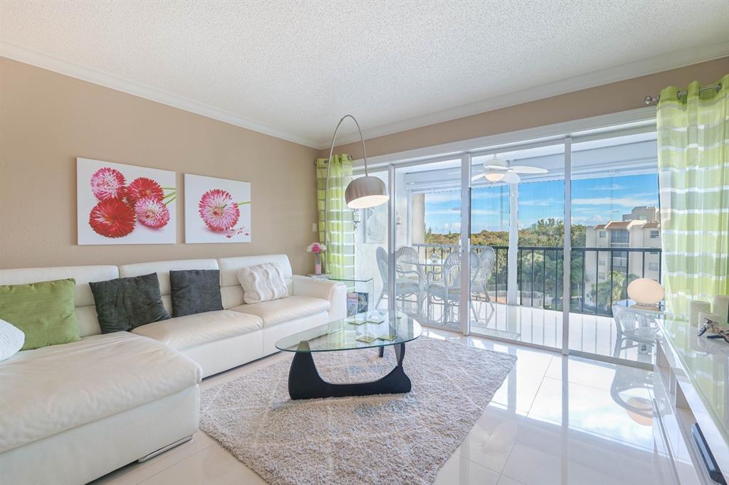 3930 Inverrary Boulevard, Unit 603D Lauderhill, FL 33319 - Photo 8 of 74 a living room with furniture and a floor to ceiling window