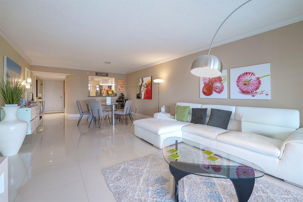 3930 Inverrary Boulevard, Unit 603D Lauderhill, FL 33319 - Photo 10 of 74 a living room with furniture and a table