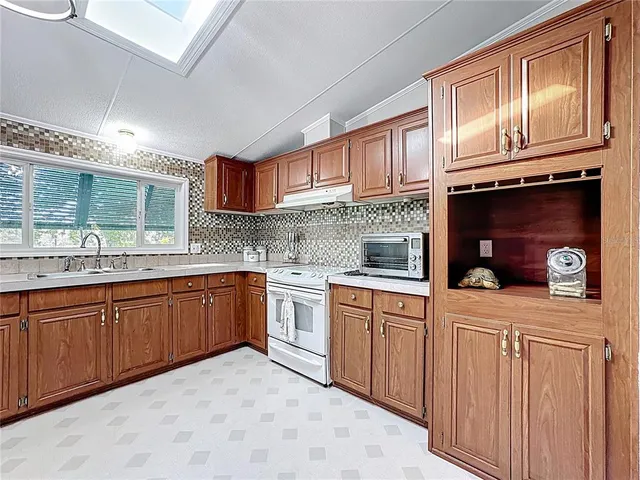 a kitchen with stainless steel appliances granite countertop a sink stove and cabinets