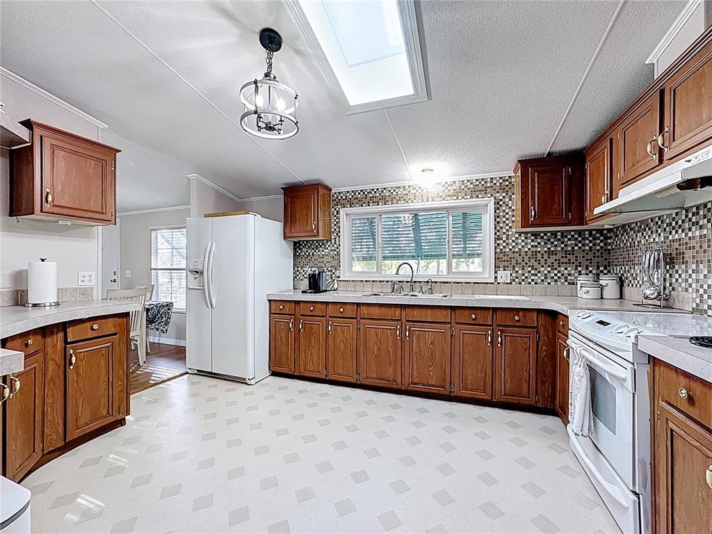 4775 Cypress Creek Ranch Road St. Cloud, FL 34773 - Photo 15 of 63 a kitchen with stainless steel appliances granite countertop a sink stove and refrigerator