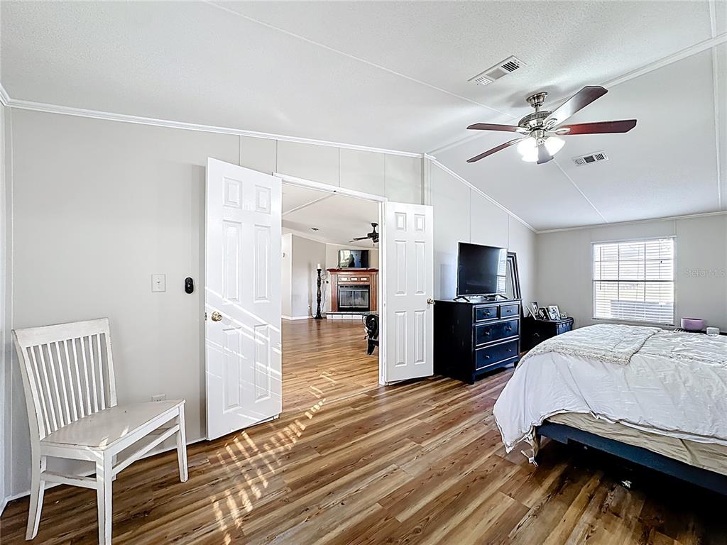 4775 Cypress Creek Ranch Road St. Cloud, FL 34773 - Photo 23 of 63 a bedroom with a bed and a chandelier