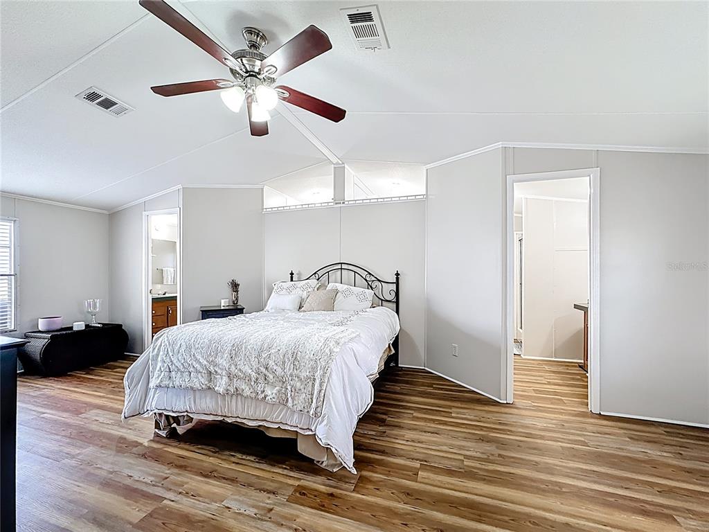 4775 Cypress Creek Ranch Road St. Cloud, FL 34773 - Photo 24 of 63 a bedroom with a bed ceiling fan and a wooden floor