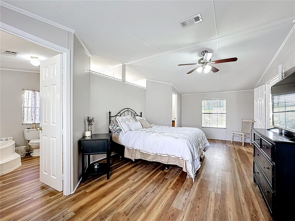 4775 Cypress Creek Ranch Road St. Cloud, FL 34773 - Photo 25 of 63 a spacious bedroom with a bed and wooden floor