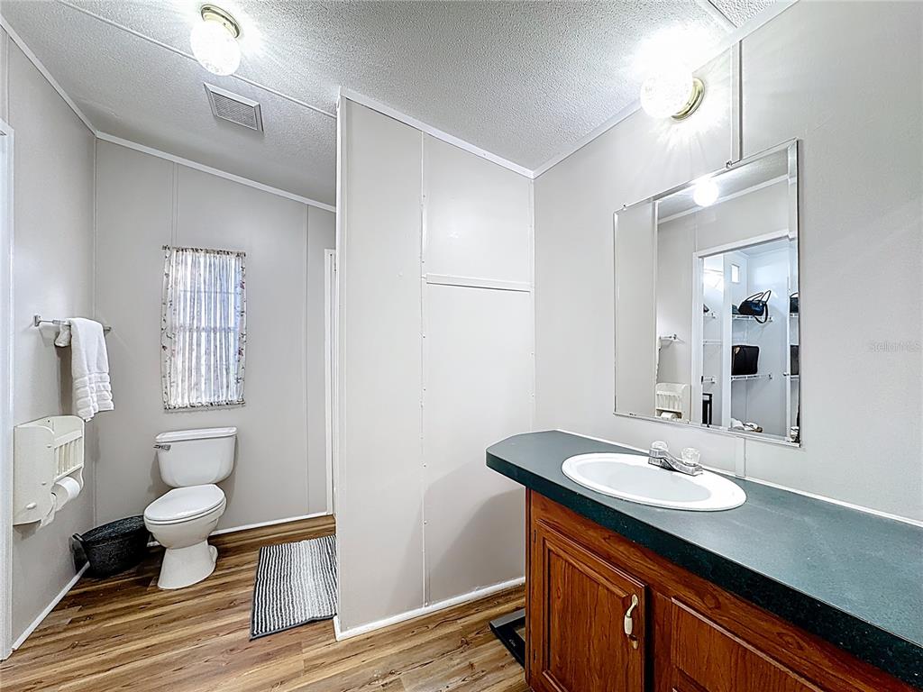 4775 Cypress Creek Ranch Road St. Cloud, FL 34773 - Photo 30 of 63 a bathroom with a sink toilet a mirror and vanity