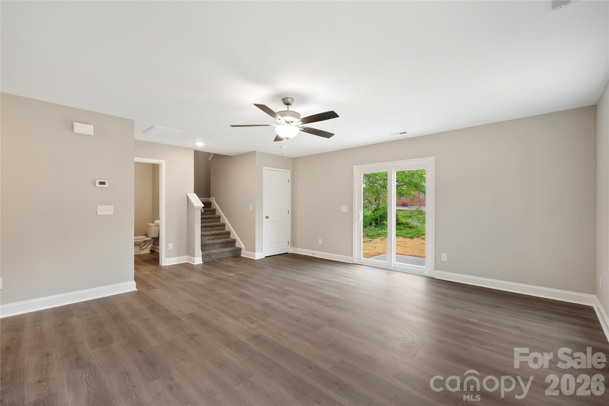 1007 Sioux Street Monroe, NC 28110 - Photo 7 of 39 an empty room with wooden floor and ceiling fan