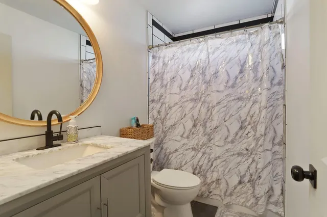 a bathroom with a toilet sink and mirror