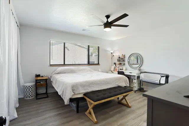 a bedroom with a large bed and a flat tv screen on dresser