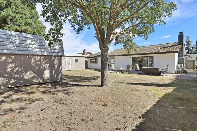 a front view of house with yard and trees around
