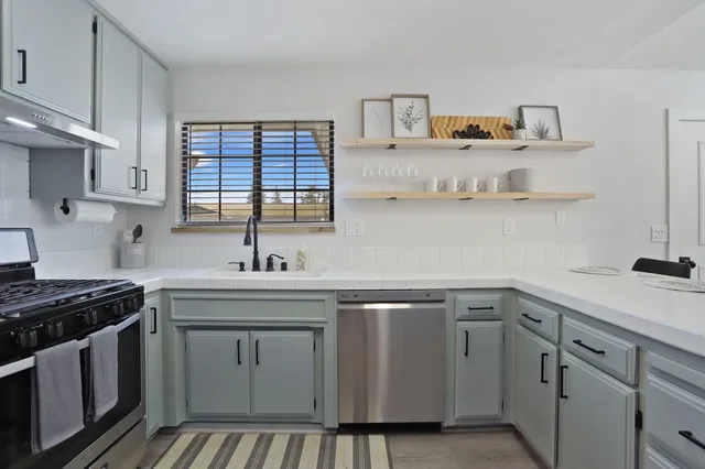 a kitchen with cabinets appliances a sink and a counter space
