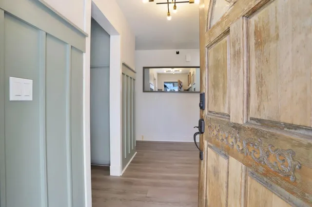a view of a hallway with wooden floor and staircase