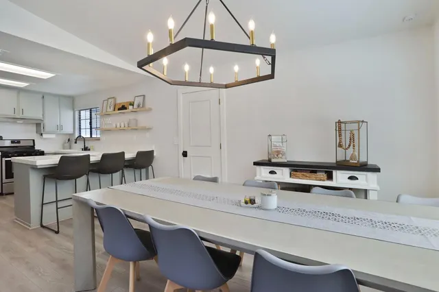 a kitchen with a dining table chairs sink and cabinets