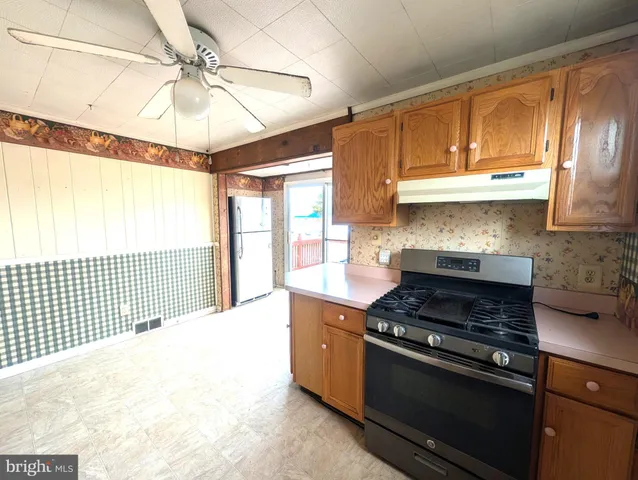 a kitchen with stainless steel appliances granite countertop a stove a sink and a refrigerator