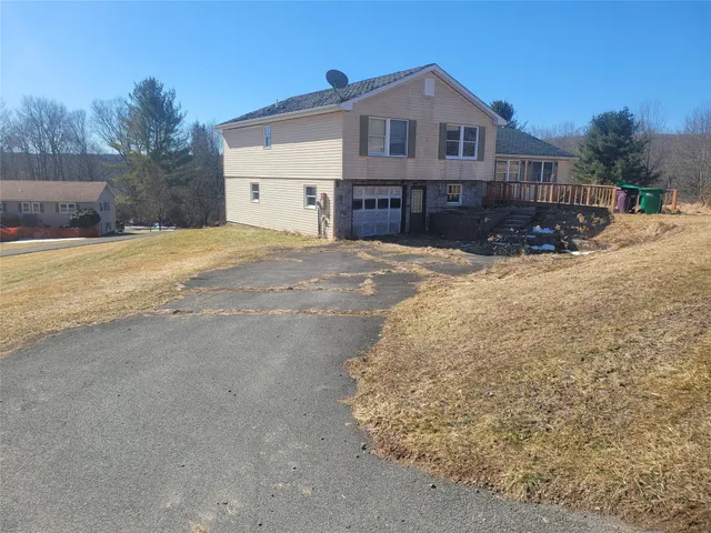 a front view of a house with a yard covered in snow