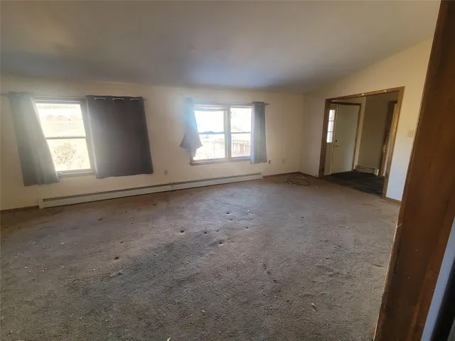 an empty room with windows and closet