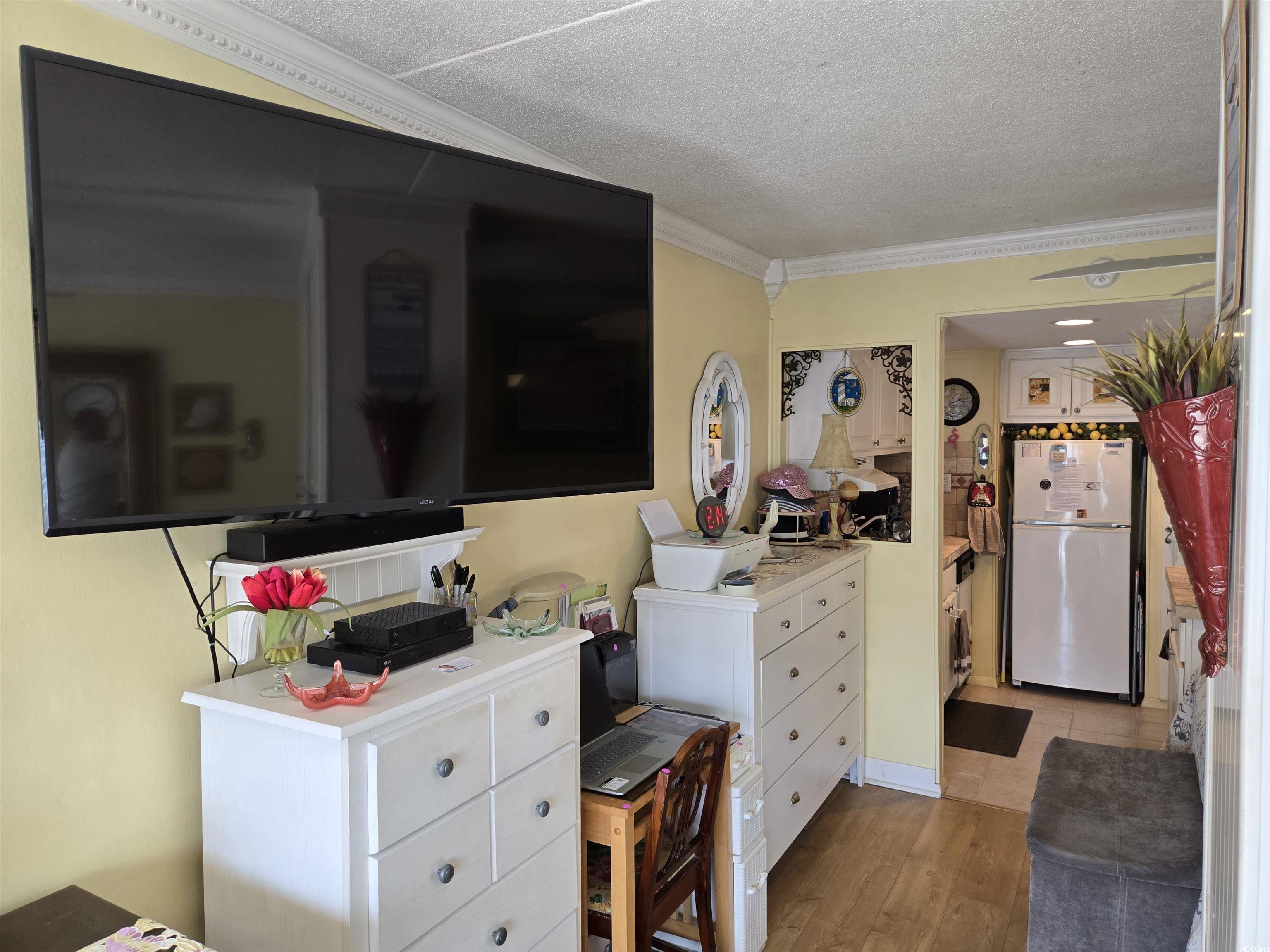 2204 Perrin Drive, Unit 3 North Myrtle Beach, SC 29582 - Photo 15 of 39 Bedroom featuring ornamental molding, white fridge, a textured ceiling, and light hardwood / wood-style flooring