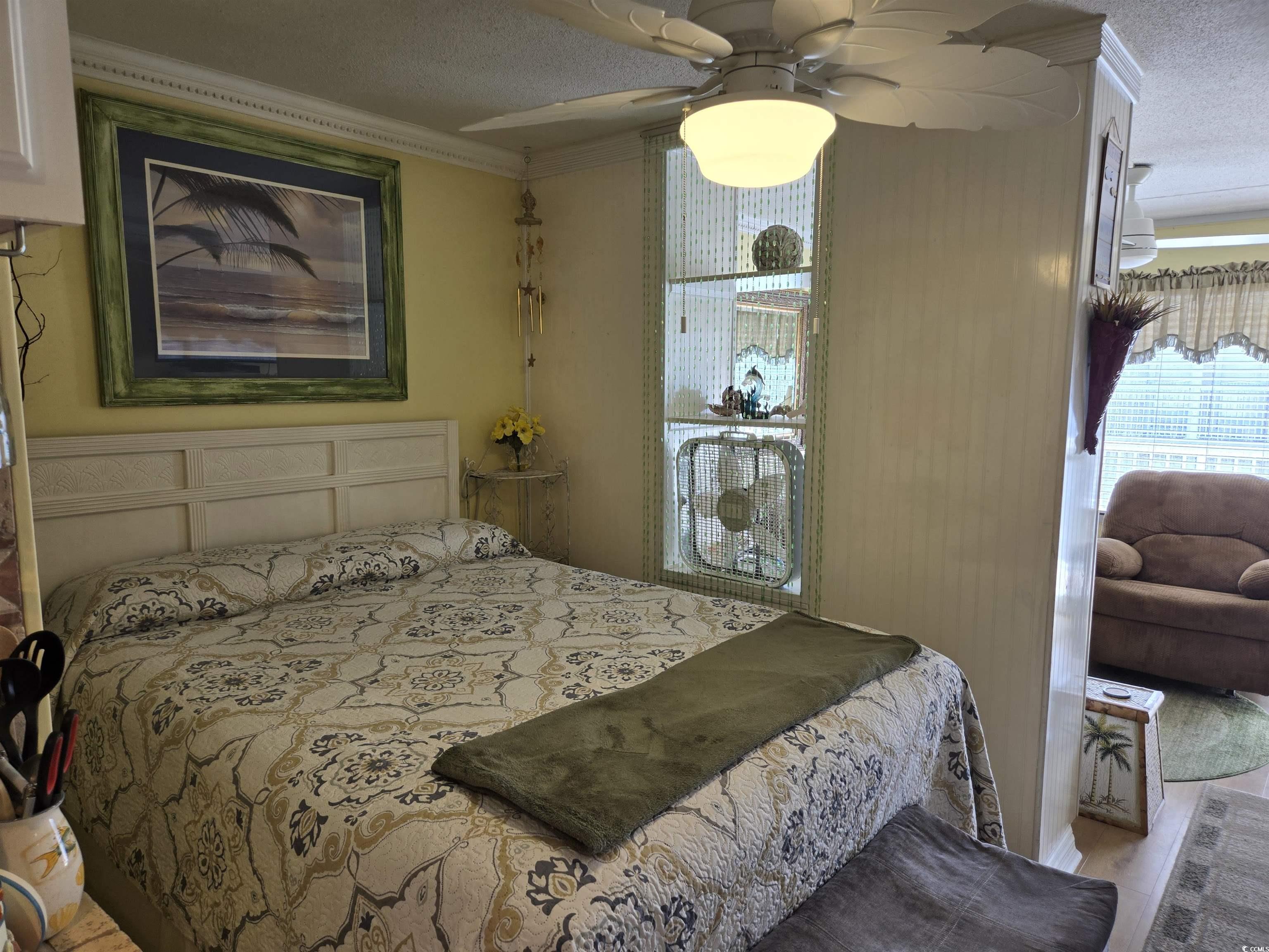 2204 Perrin Drive, Unit 3 North Myrtle Beach, SC 29582 - Photo 25 of 39 Bedroom with ceiling fan, ornamental molding, light wood-type flooring, and a textured ceiling