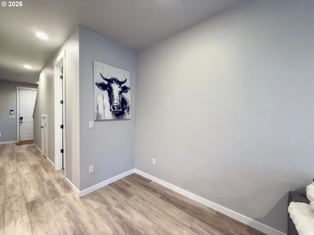 a view of a hallway with wooden floor and closet