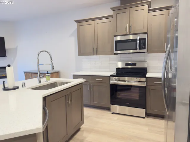 a kitchen with a sink and stainless steel appliances