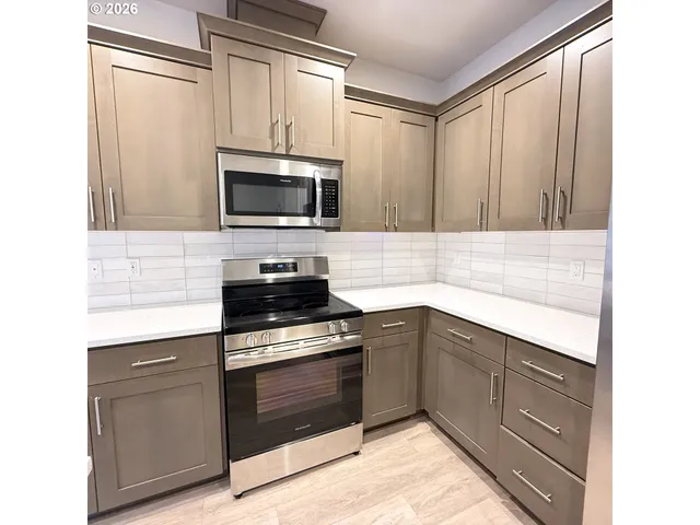 a kitchen with granite countertop cabinets stainless steel appliances and a window
