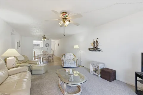 a living room with furniture a chandelier and a mirror