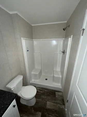 a bathroom with a toilet and a shower
