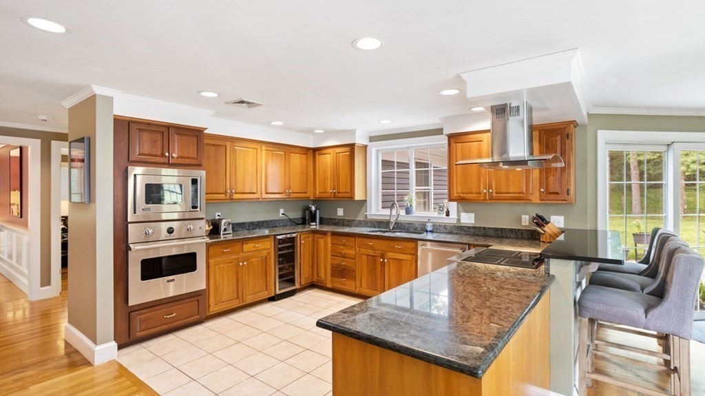 18 Pine Street Dover, MA 02030 - Photo 3 of 20 a kitchen with stainless steel appliances granite countertop a stove top oven a sink dishwasher a dining table and chairs with wooden floor