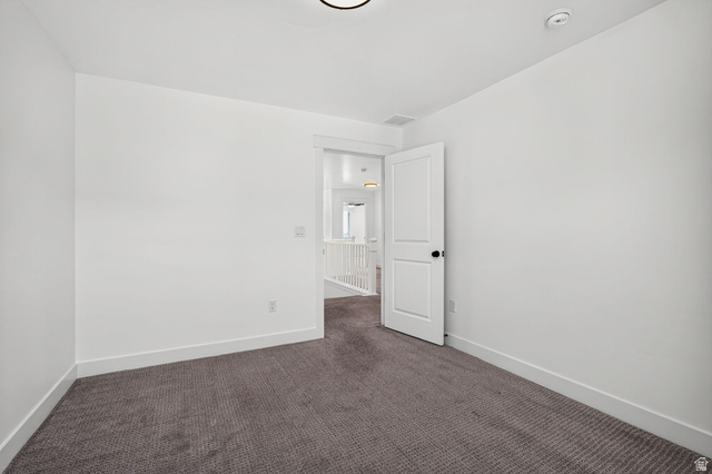 6536 West Muirfield Road Highland, UT 84003 - Photo 38 of 48 Bright room featuring white walls, deep gray carpeting, white baseboards, and a white interior door with black hardware