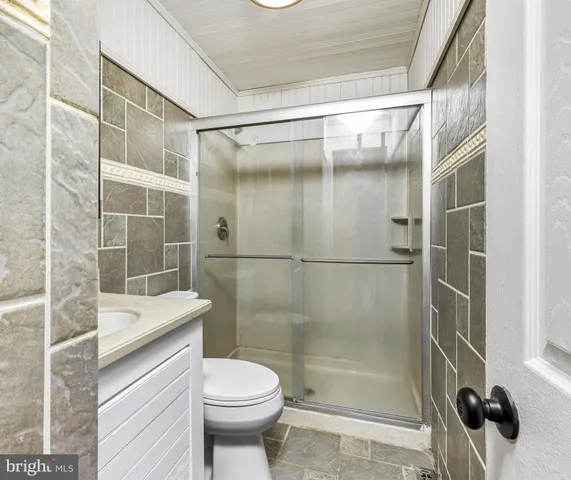 a bathroom with a shower a toilet and a sink