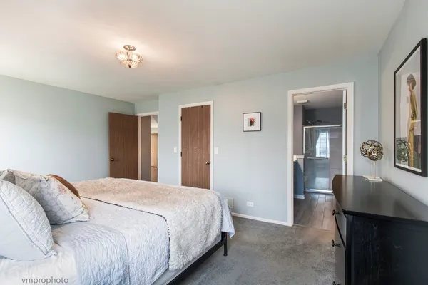 a bedroom with a large bed and wooden floor