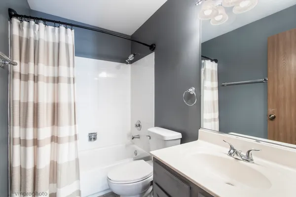 a bathroom with a double vanity sink toilet and shower