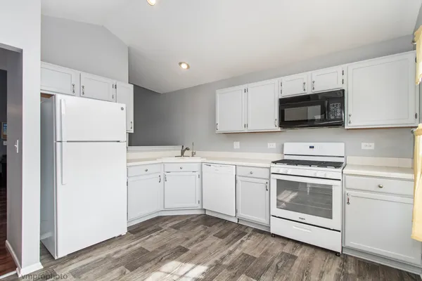 a kitchen with white cabinets and white stainless steel appliances