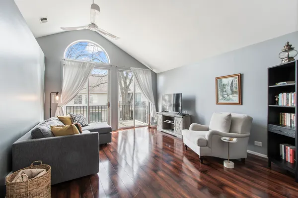 a living room with furniture floor to ceiling window and a flat screen tv