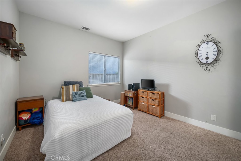 159 Ash Avenue Cayucos, CA 93430 - Photo 31 of 44 a bedroom with a bed and a chandelier