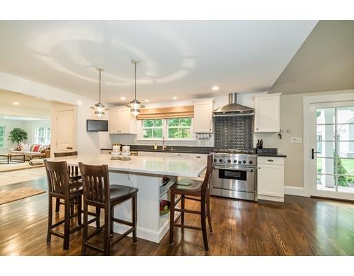 1073 Bay Road Hamilton, MA 01982 - Photo 11 of 36 a kitchen with stainless steel appliances kitchen island granite countertop a table chairs stove and white cabinets