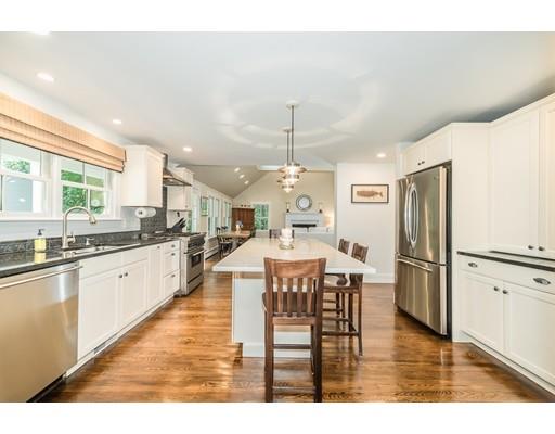 1073 Bay Road Hamilton, MA 01982 - Photo 12 of 36 a large kitchen with a table chairs refrigerator and microwave