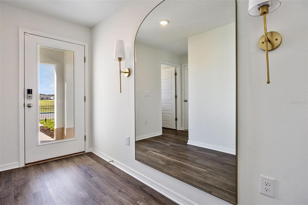 4257 Fennec Fox Way Lakeland, FL 33810 - Photo 2 of 29 a view of a hallway with wooden floor and staircase