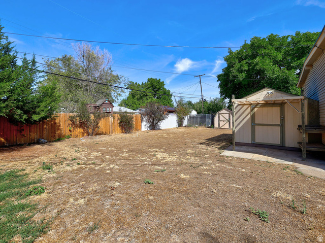 669 Colonial Avenue Layton, UT 84041 - Photo 37 of 51 Expansive backyard featuring a wood fence, storage shed, and a secondary storage shed