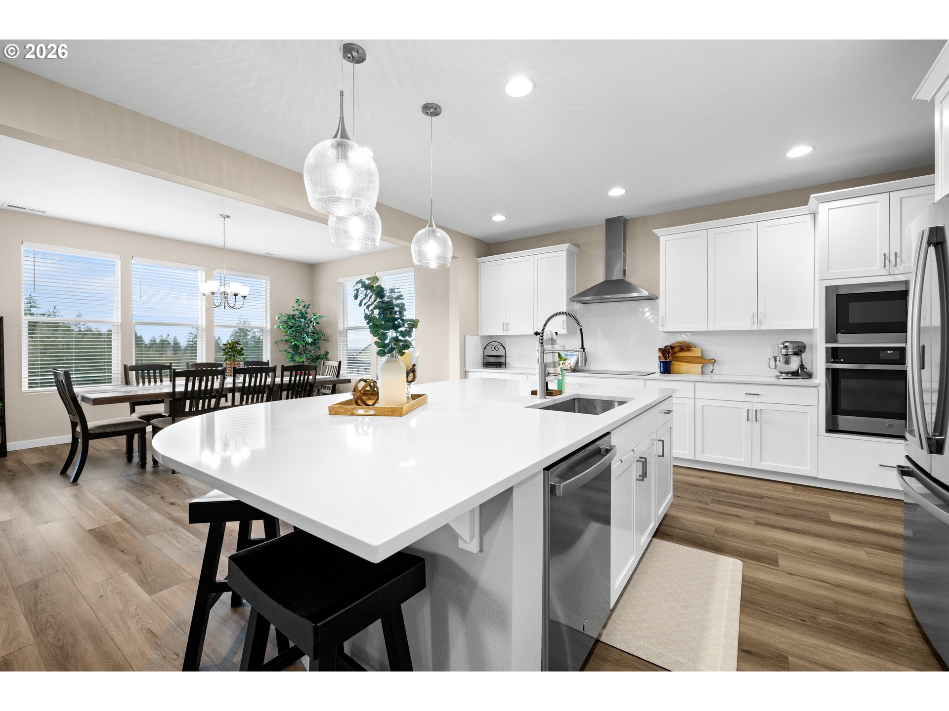 2081 Northeast Ridge Run Lane Estacada, OR 97023 - Photo 16 of 46 a kitchen with a refrigerator a sink dishwasher a dining table and chairs with wooden floor