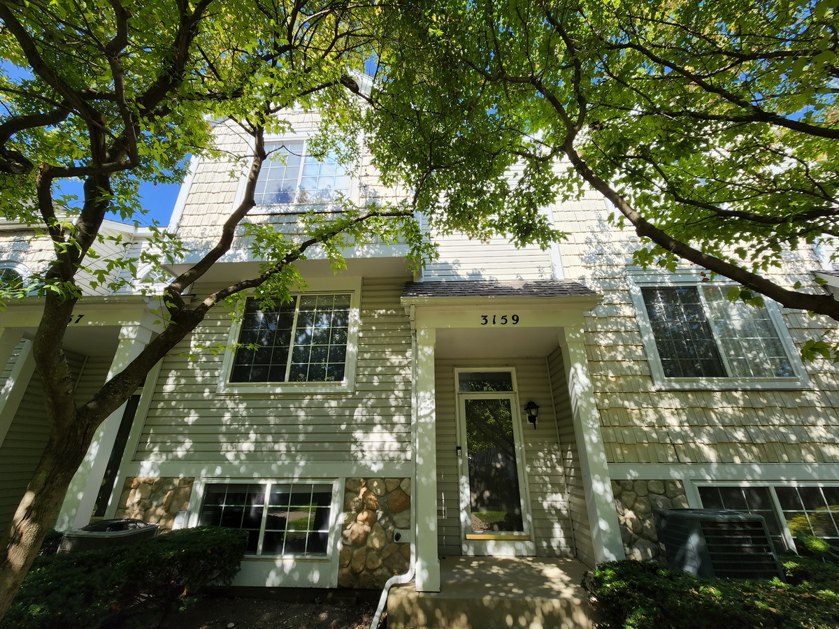 a front view of a house with a tree