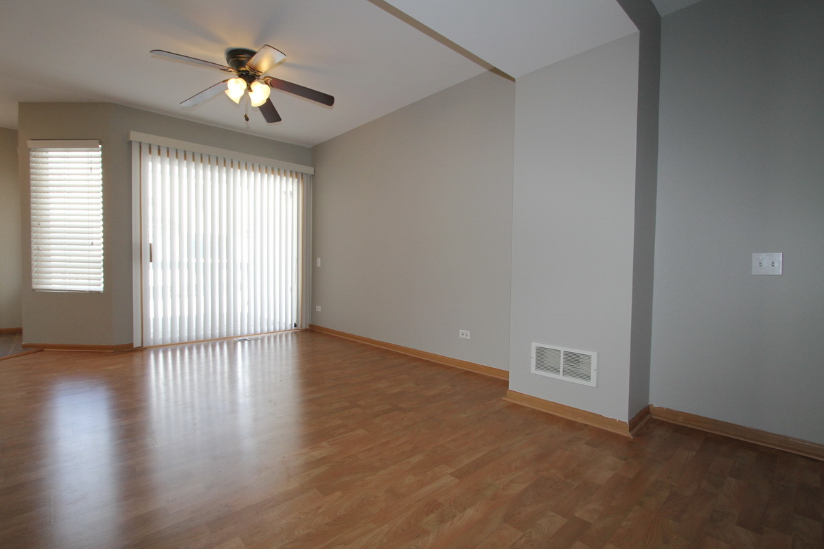 3159 Cambria Court Aurora, IL 60503 - Photo 4 of 20 an empty room with wooden floor chandelier and windows