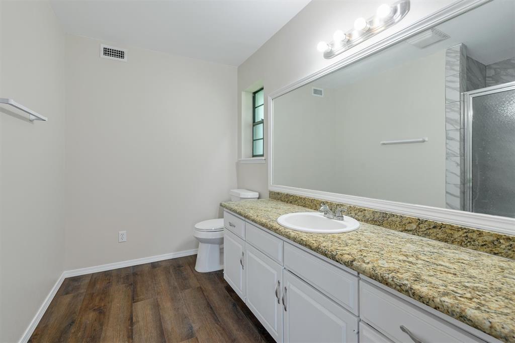 209 Mistletoe Lane Keene, TX 76059 - Photo 20 of 38 a bathroom with a granite countertop sink a toilet and a mirror