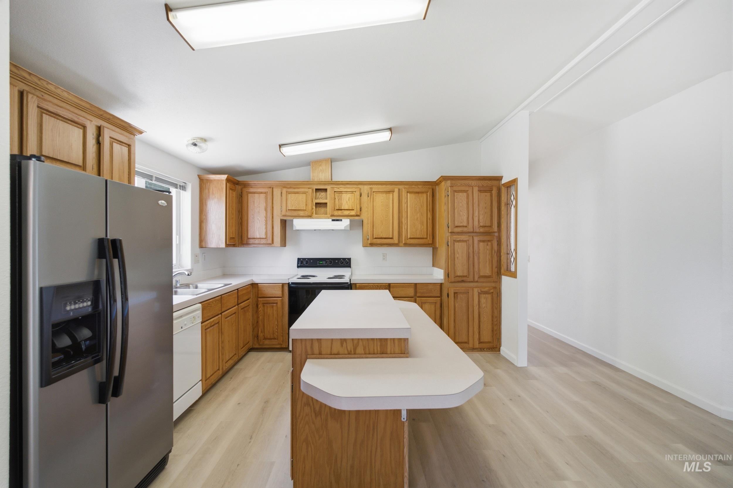 7422 Track Road Nampa, ID 83686 - Photo 10 of 50 Kitchen featuring wood cabinetry, light countertops, and wood-finish flooring