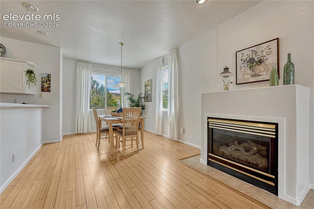 7285 Julynn Road Colorado Springs, CO 80919 - Photo 8 of 45 a dining room with furniture a fireplace and wooden floor