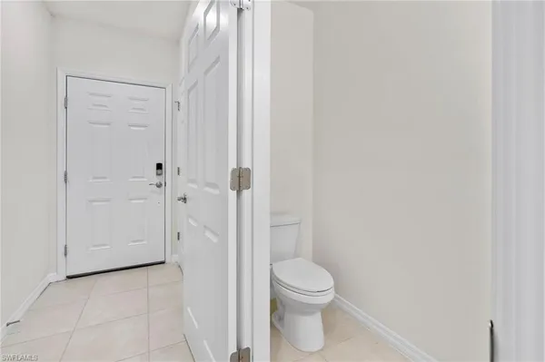 a large white kitchen with stainless steel appliances a large counter top a stove a microwave a sink a refrigerator and white cabinets