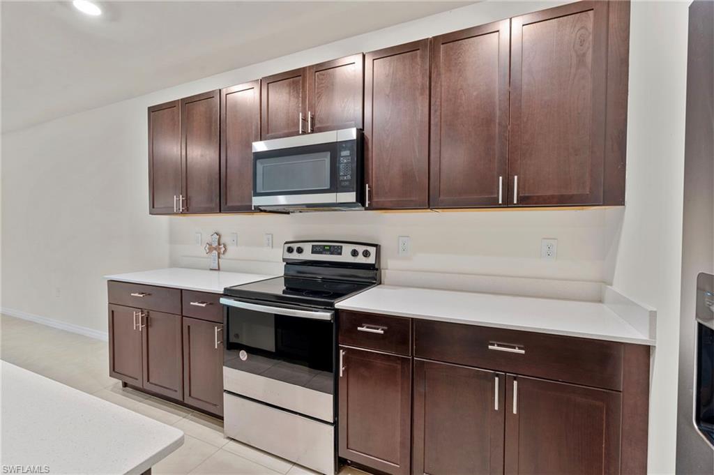 15535 Wildflower Circle Naples, FL 34119 - Photo 5 of 33 a kitchen with a sink stove and microwave