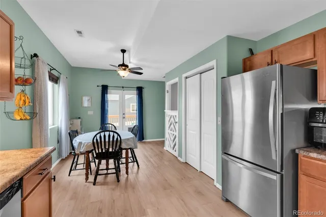 a kitchen with stainless steel appliances granite countertop a refrigerator and a dining table