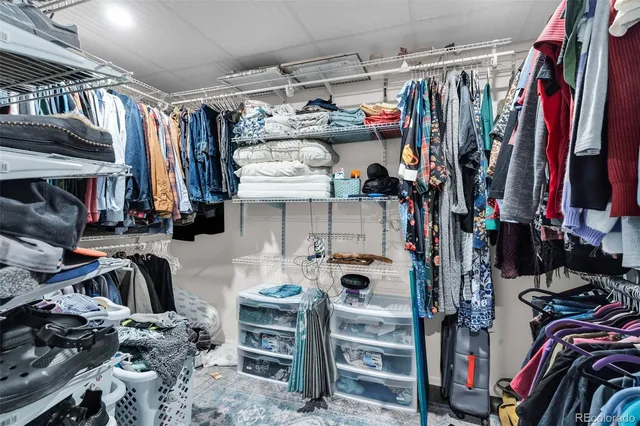 a view of walk in closet with clothes and shoes
