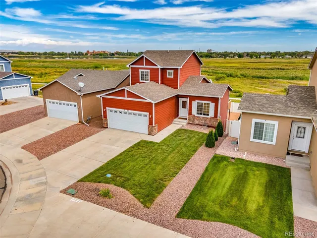 an aerial view of residential houses with outdoor space and ocean view