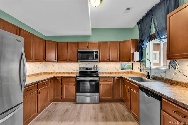 a kitchen with a sink stove microwave and refrigerator